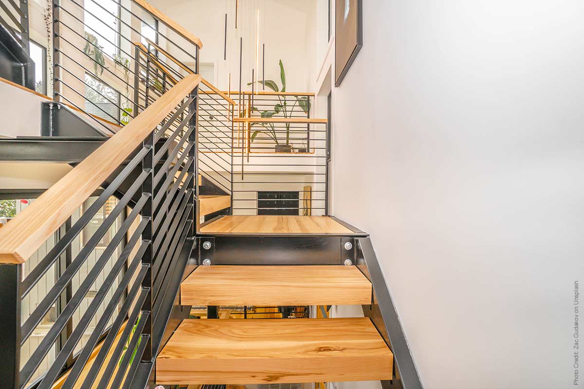 Modern staircase with wooden treads and metal railings going up