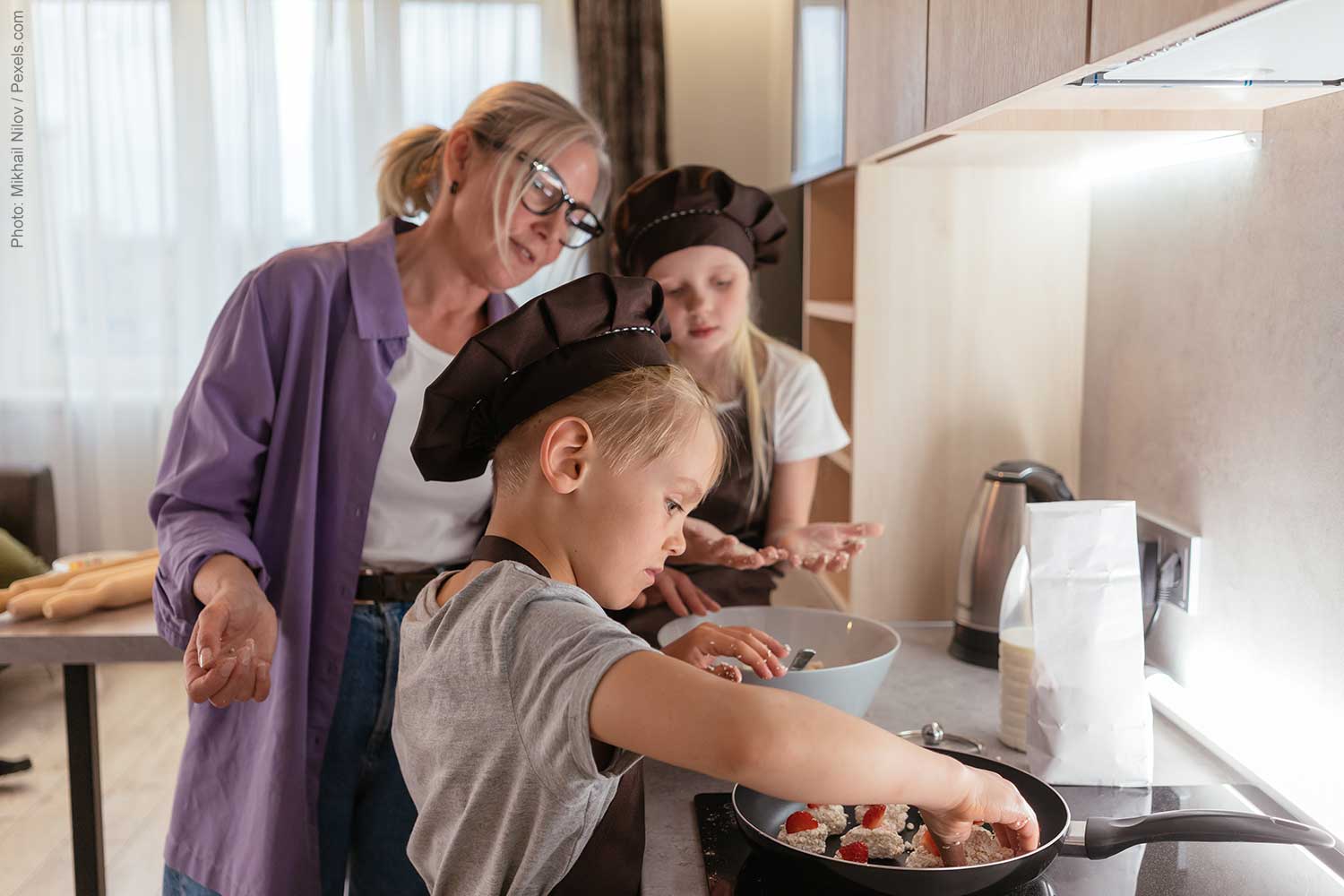 Woman and 2 little girls cooking together and enjoying the benefits of a kitchen remodel