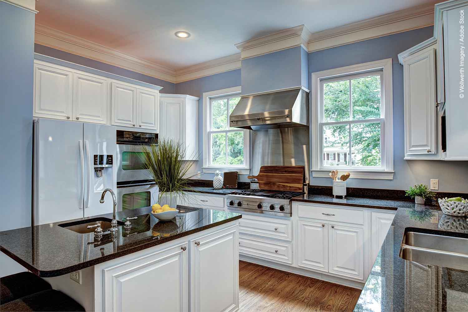 Large kitchen interior with granite countertops and light blue walls